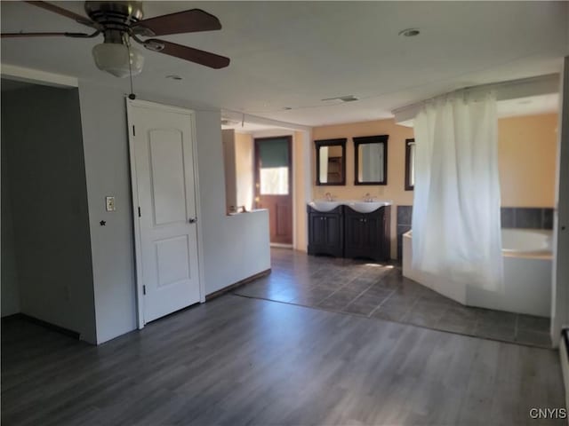 empty room featuring visible vents, dark wood-style floors, and ceiling fan