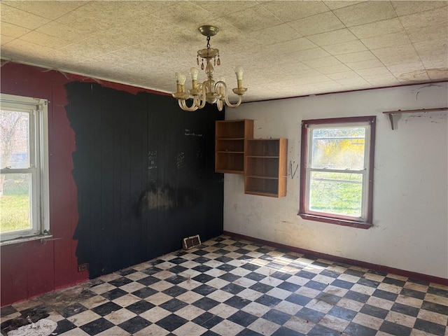 spare room featuring a chandelier, visible vents, and tile patterned floors