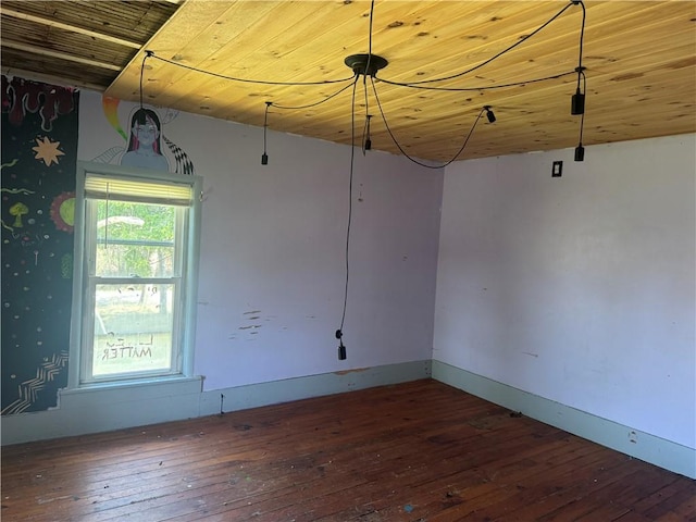spare room featuring wood-type flooring, wooden ceiling, and baseboards