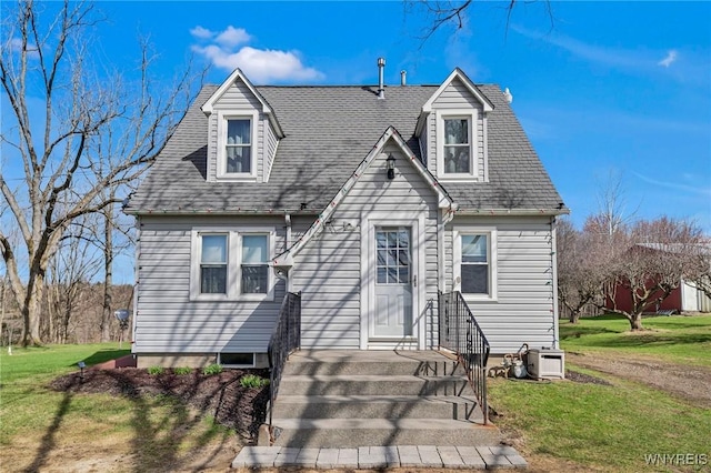 cape cod home featuring a shingled roof and a front yard