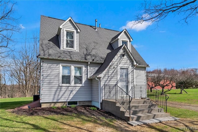 cape cod home with a front lawn