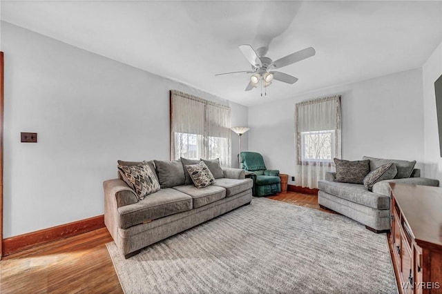 living room with wood finished floors, a ceiling fan, and baseboards