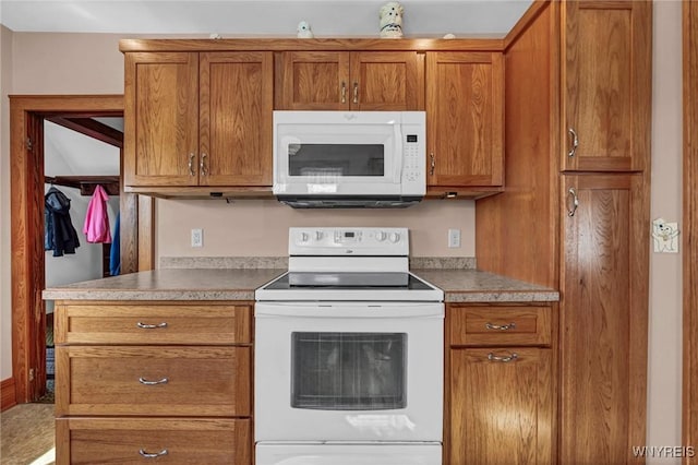 kitchen featuring brown cabinetry and white appliances