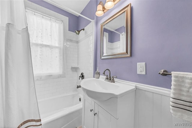 bathroom with shower / bath combo, vanity, and wainscoting