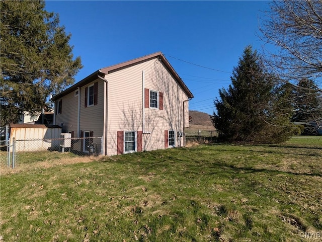 view of home's exterior with a lawn and fence