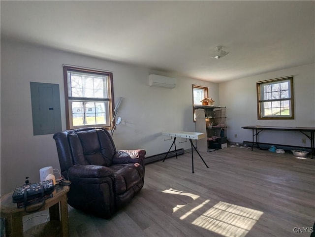 sitting room with electric panel, wood finished floors, a wealth of natural light, and a wall unit AC