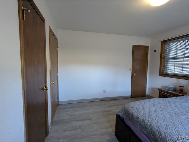 bedroom with baseboards and light wood-style floors