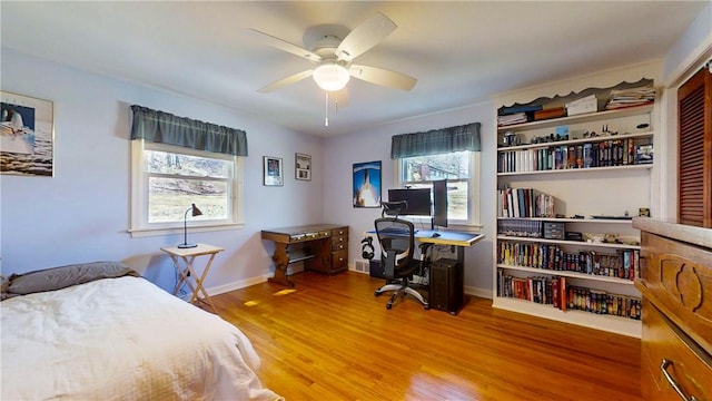 bedroom with wood finished floors, baseboards, and ceiling fan