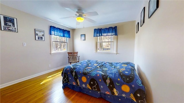 bedroom featuring ceiling fan, baseboards, and wood finished floors
