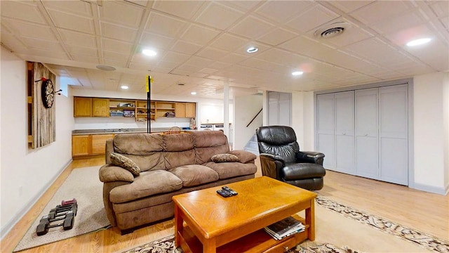 living area featuring light wood-type flooring, visible vents, and baseboards