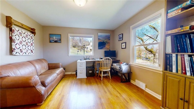 office area featuring light wood-style floors, visible vents, and baseboards