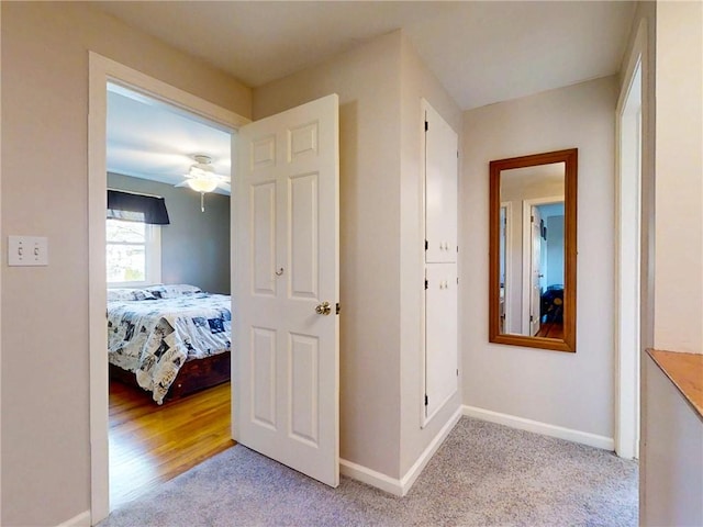 corridor with light carpet and baseboards