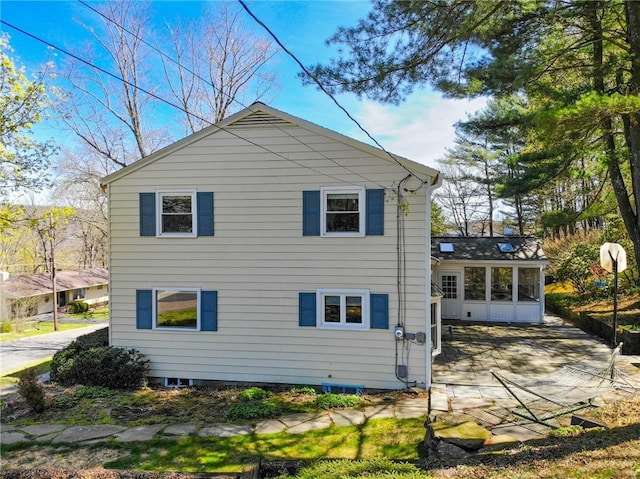 rear view of house with a sunroom and a patio
