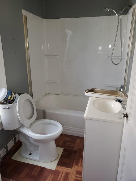 full bath featuring toilet, vanity, and  shower combination