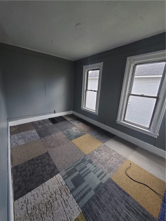 carpeted empty room with baseboards