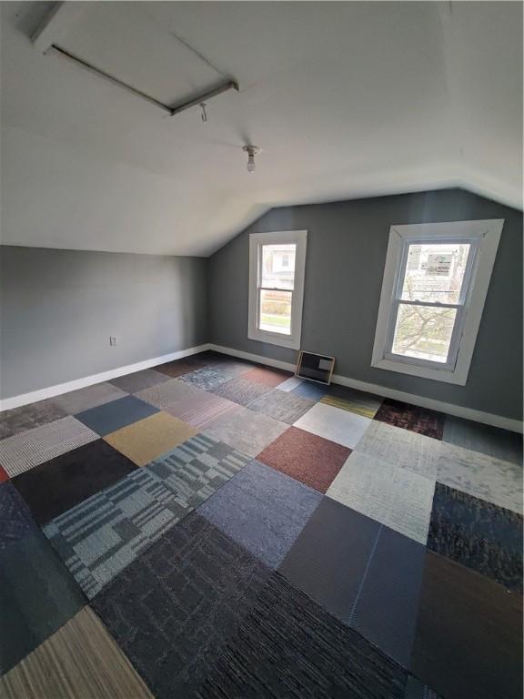 bonus room with vaulted ceiling and baseboards