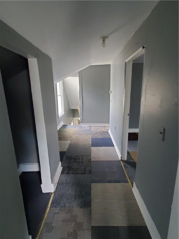 bonus room featuring lofted ceiling and baseboards
