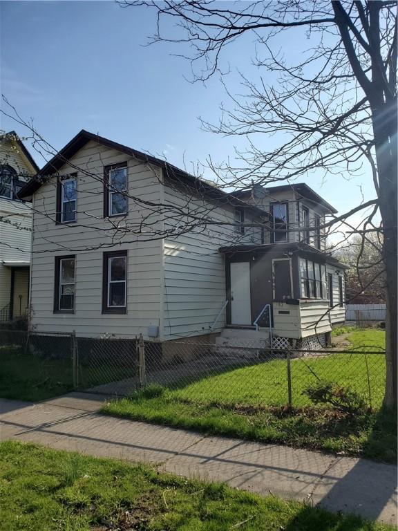 view of front facade with a front lawn and a fenced front yard