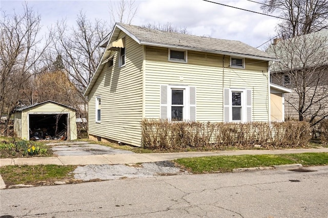 view of property exterior with concrete driveway, an outbuilding, and a detached garage
