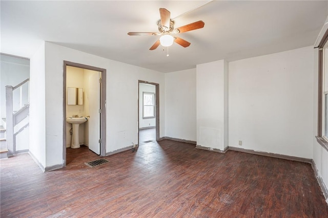 unfurnished bedroom featuring wood finished floors, visible vents, baseboards, and a sink