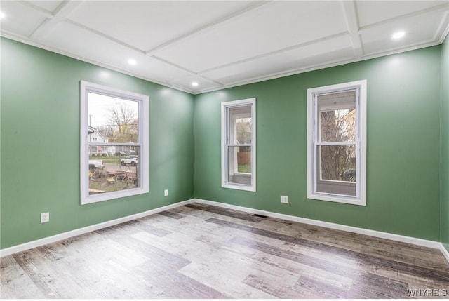 spare room featuring plenty of natural light, wood finished floors, and coffered ceiling
