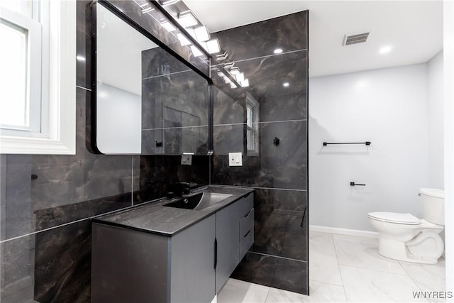 bathroom with vanity, marble finish floor, baseboards, toilet, and visible vents