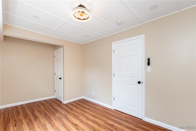 spare room featuring wood finished floors and baseboards