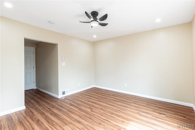 spare room featuring a ceiling fan, wood finished floors, baseboards, visible vents, and recessed lighting