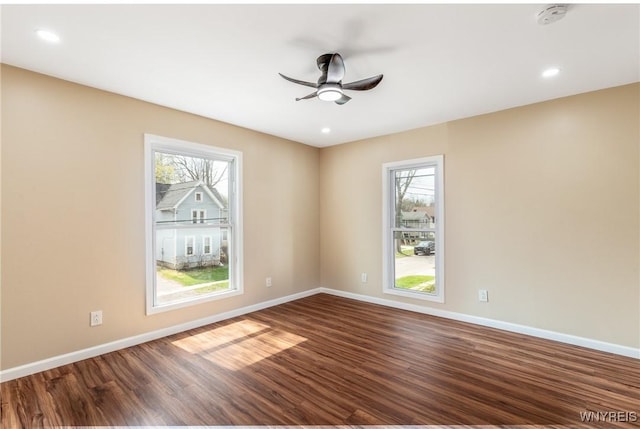 spare room with plenty of natural light, a ceiling fan, and dark wood-style flooring