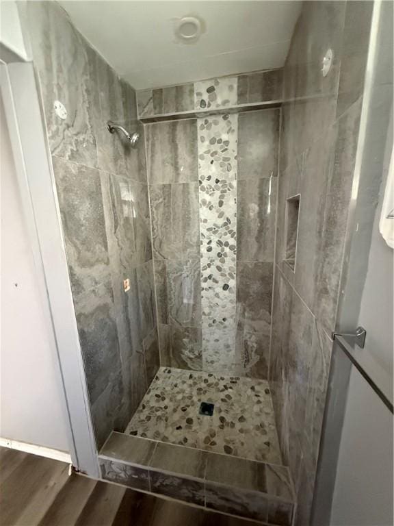 bathroom with a shower stall and wood finished floors