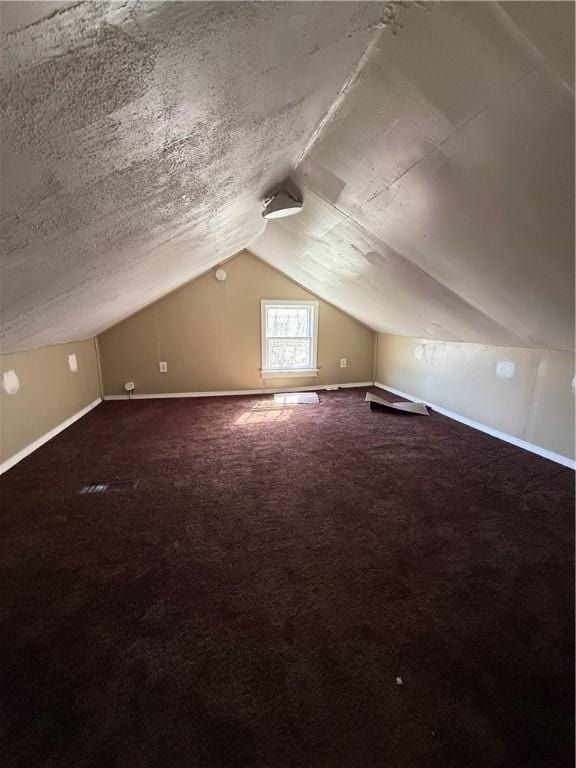 additional living space featuring lofted ceiling, carpet floors, and baseboards