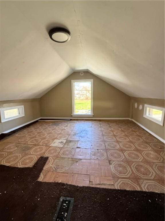 additional living space with vaulted ceiling, baseboards, and a healthy amount of sunlight