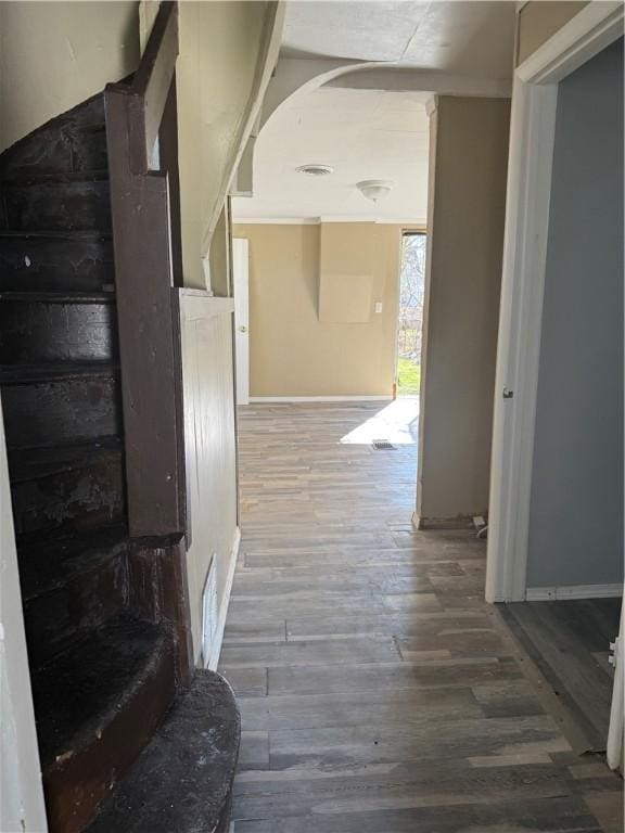 corridor featuring visible vents, baseboards, and wood finished floors