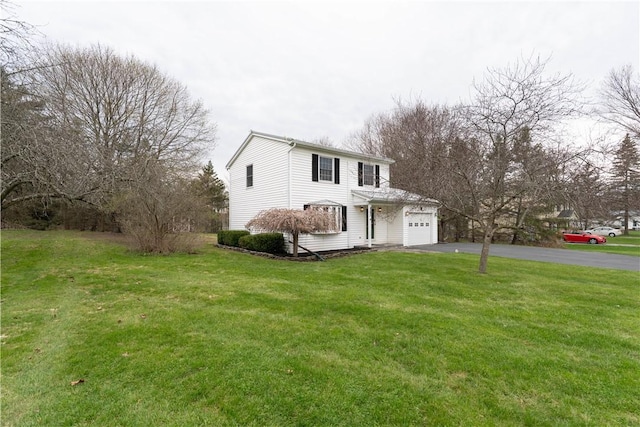 traditional-style home with a garage, a front yard, and aphalt driveway