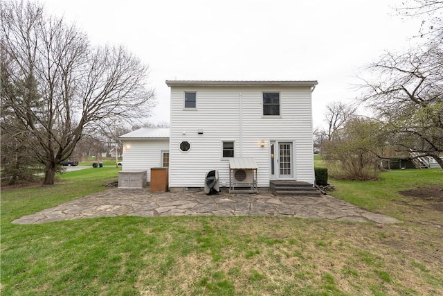 back of house featuring a lawn and metal roof