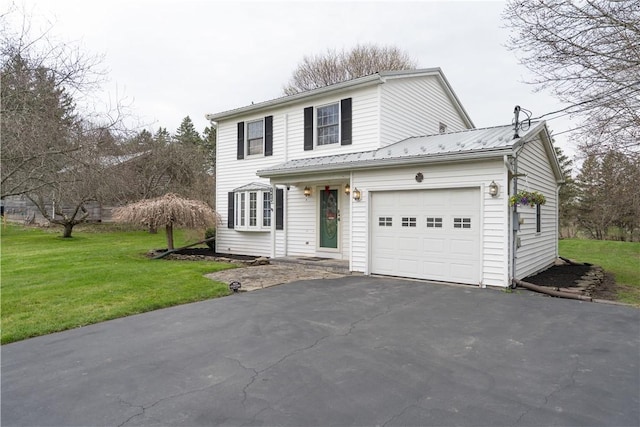 traditional-style home featuring an attached garage, a front lawn, metal roof, and driveway