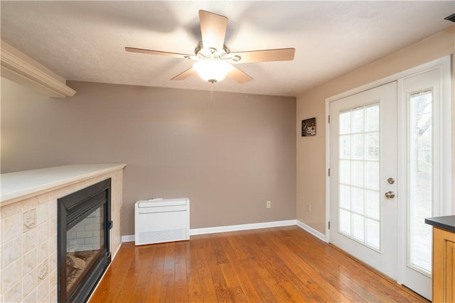 unfurnished living room featuring baseboards, light wood finished floors, and a fireplace