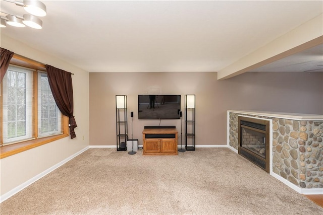 living area with light carpet, a stone fireplace, and baseboards