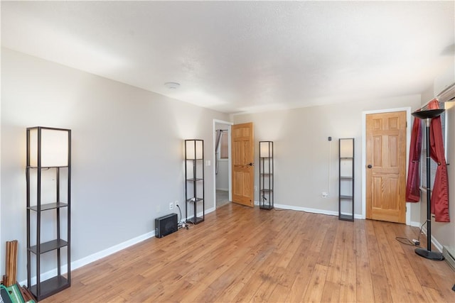 unfurnished living room featuring light wood-style flooring and baseboards