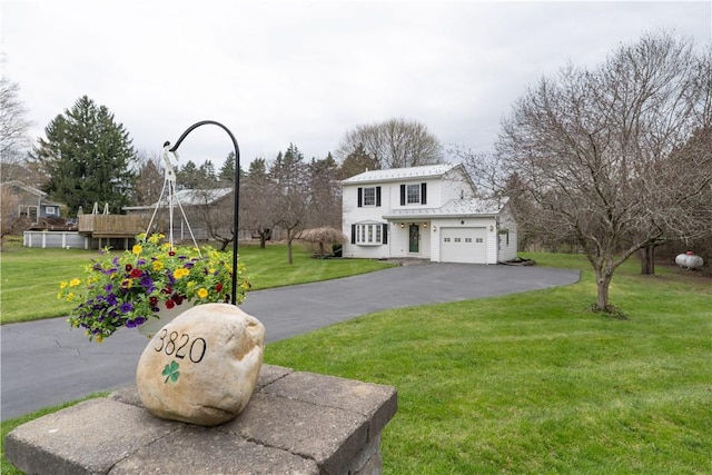 view of front of home with an attached garage, driveway, and a front yard
