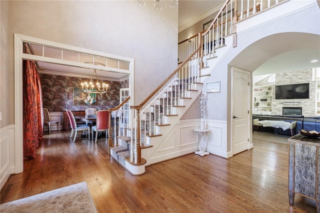 5 Ponds Edge Way, Pittsford, NY 14534 - stairs with arched walkways, a chandelier, built in shelves, wood finished floors, and a decorative wall