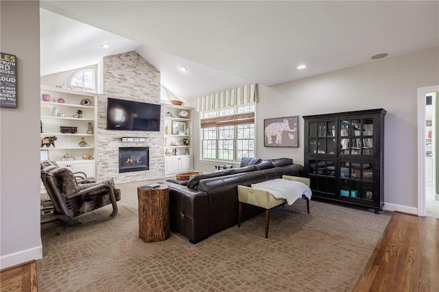 5 Ponds Edge Way, Pittsford, NY 14534 - living room featuring baseboards, built in features, lofted ceiling, wood finished floors, and a large fireplace