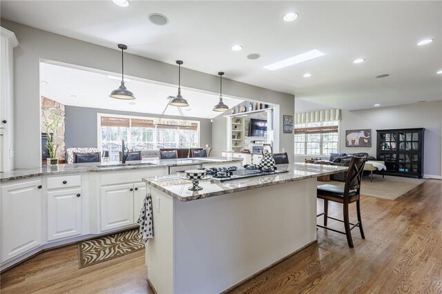 5 Ponds Edge Way, Pittsford, NY 14534 - kitchen with light wood finished floors, open floor plan, white cabinetry, and a sink