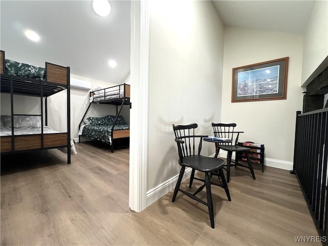 dining area with baseboards, vaulted ceiling, and wood finished floors