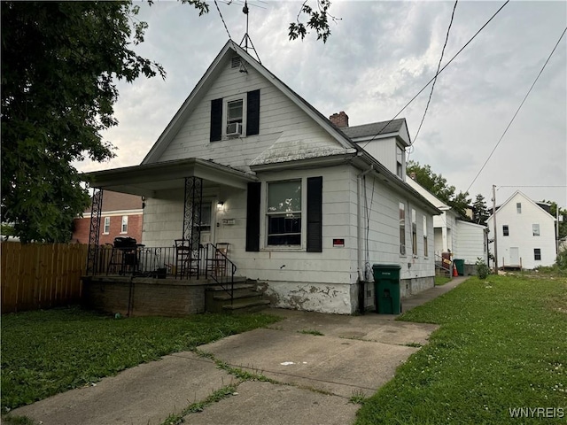 bungalow-style house with a chimney, a front lawn, fence, and cooling unit