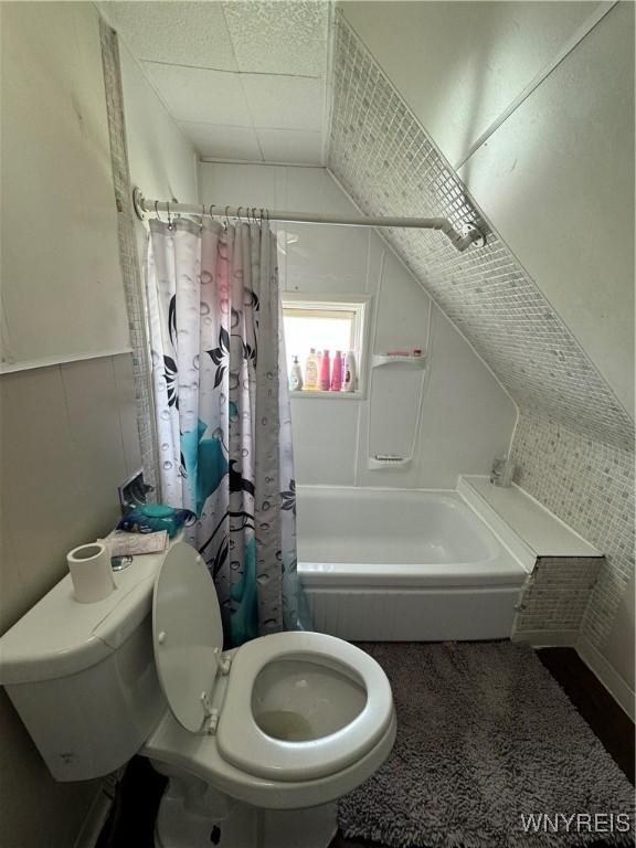 bathroom featuring shower / tub combo and toilet