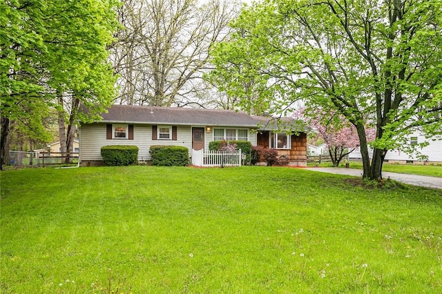 ranch-style house featuring a front yard and fence