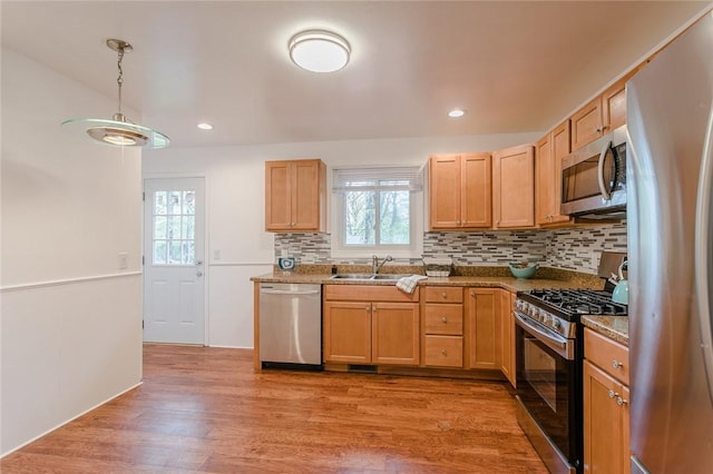 kitchen with plenty of natural light, tasteful backsplash, stainless steel appliances, and a sink