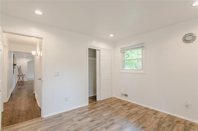 unfurnished bedroom featuring recessed lighting, light wood-style flooring, visible vents, and baseboards