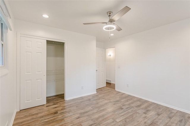 unfurnished bedroom with light wood-style flooring, baseboards, recessed lighting, and a closet